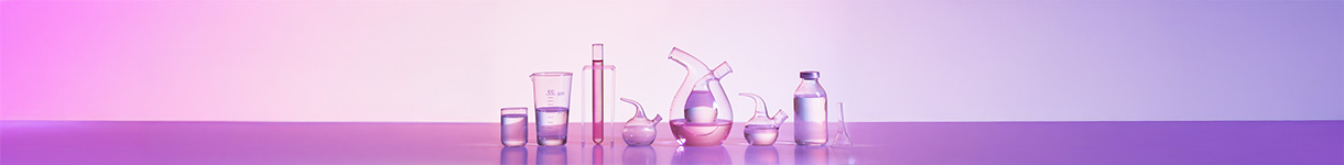 Assorted glass beakers and bottles containing clean beauty formulations in soft pink tones.