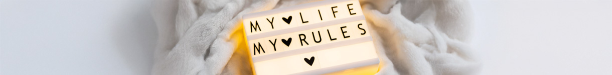 Person holding a lightbox that reads ‘My Life My Rules,’ expressing personal empowerment and self-care autonomy