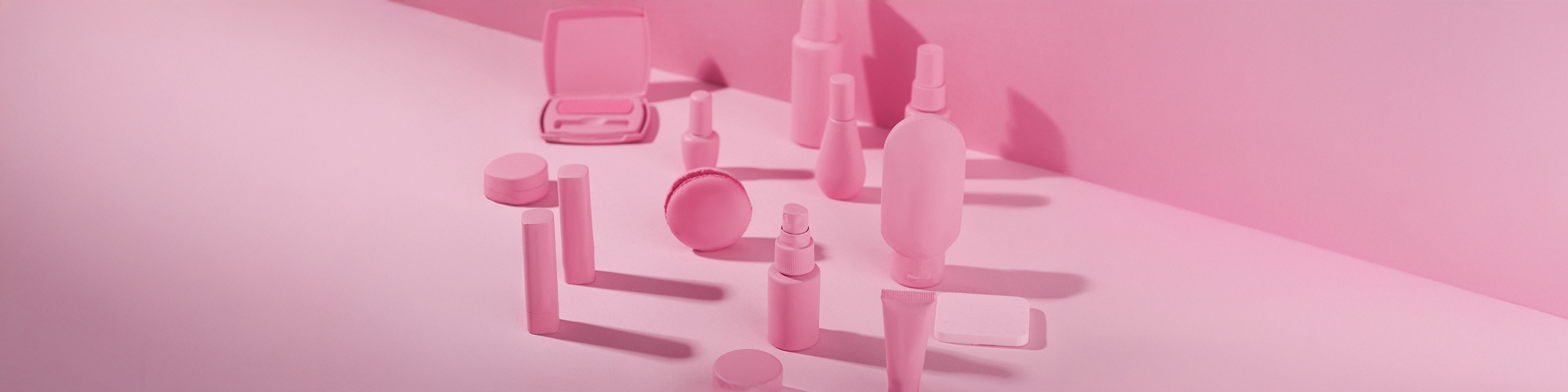 Monochrome pink flatlay of makeup and skincare products symbolizing beauty brand startup expectations.