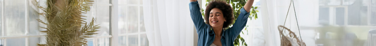 Woman stretching joyfully in a bright morning room, embracing a refreshed and energized start to the day