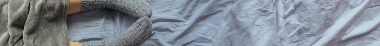 Soft blanket and cozy bedding in muted tones, illustrating evening comfort and a calming night routine.