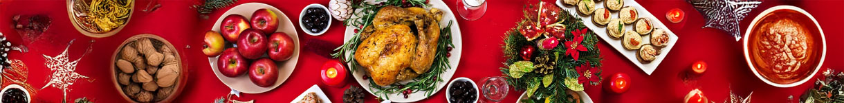 Overhead view of a Christmas dinner table filled with festive dishes, desserts, and holiday decorations.