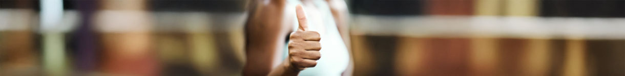 Woman giving a thumbs-up gesture while smiling, representing gentle wins and soft-life routines for the New Year.