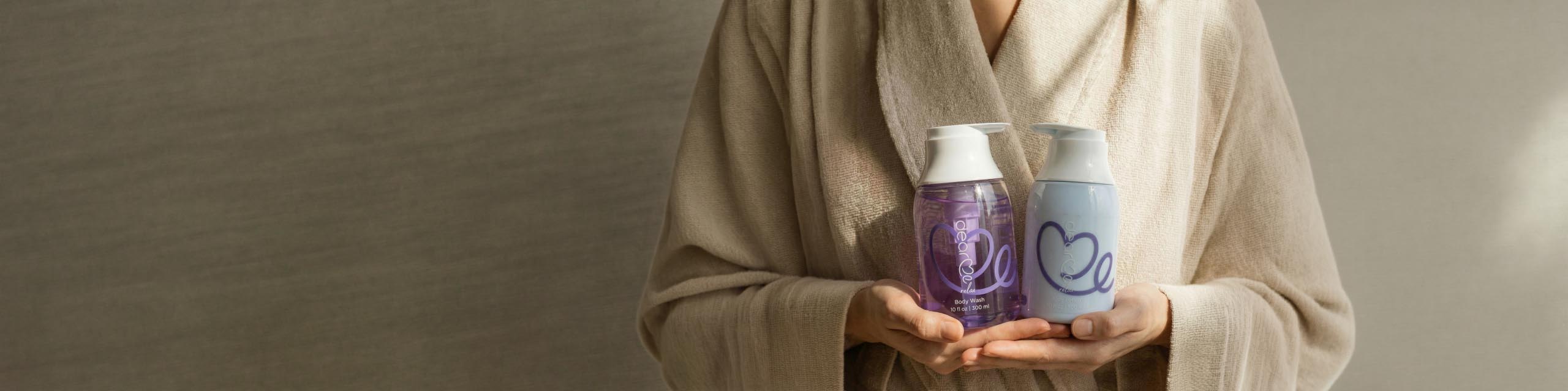 Relaxing shower routine woman in a cozy robe after relaxing shower with dear me relax gift set bofy wash and body lotion on her hands