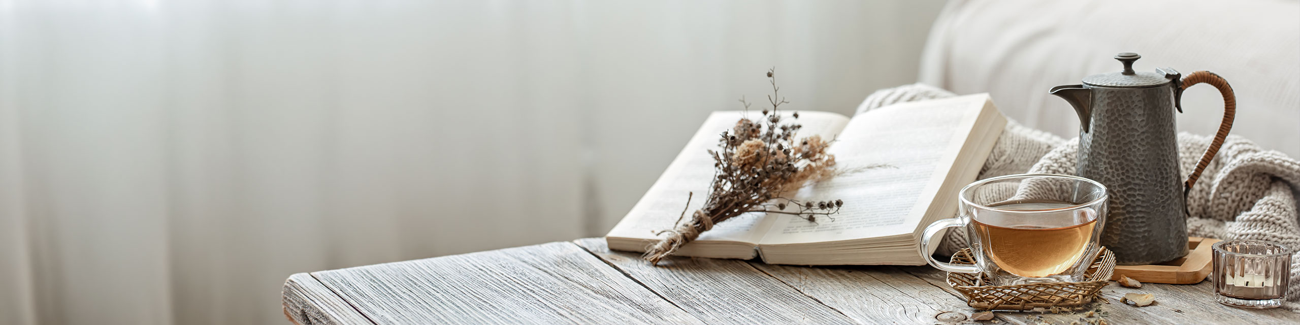Cozy reading nook with open book tea cup and kettle representing slow living mindful lifestyle